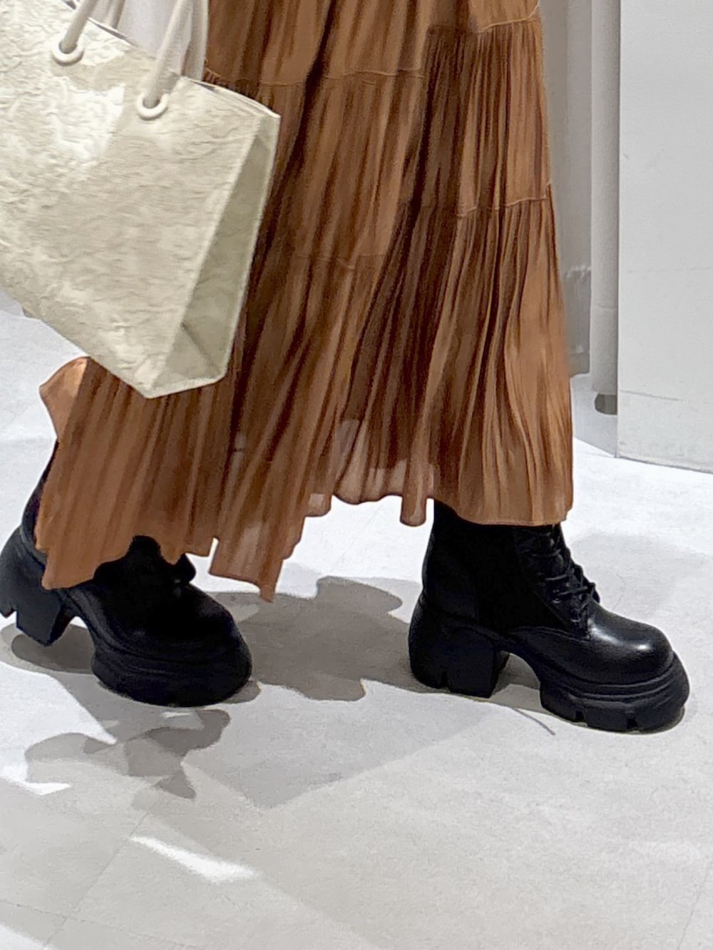 ホワイト系のTシャツ/カットソー、ベージュ系のスカート、ホワイト系のトートバッグを着用したレディースの秋コーディネートの5枚目の写真