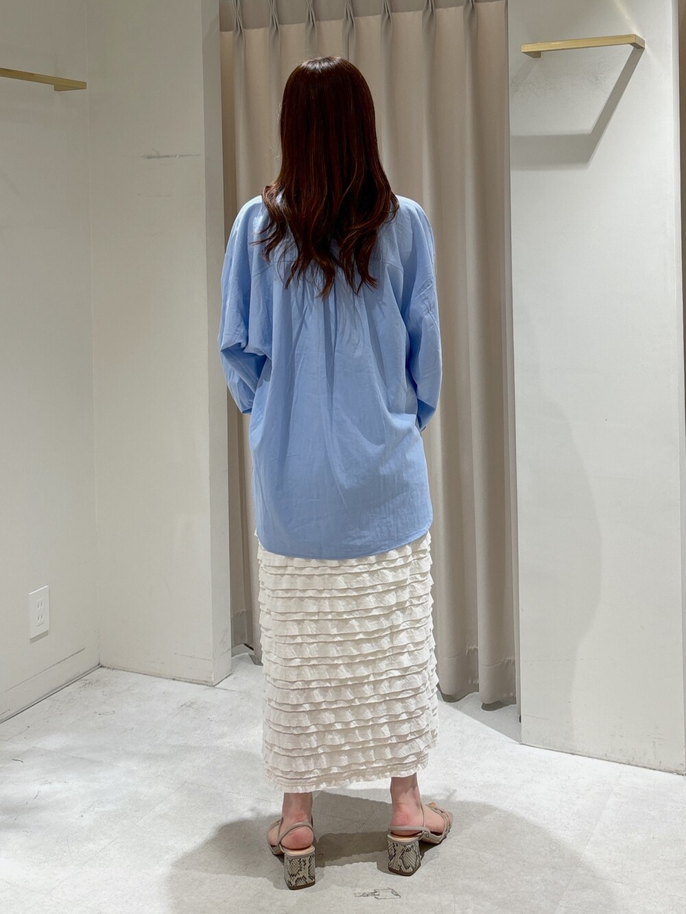 ブラック系のショルダーバッグ、ホワイト系のスカート、ホワイト系のキャミソールを着用したレディースの春コーディネートの5枚目の写真