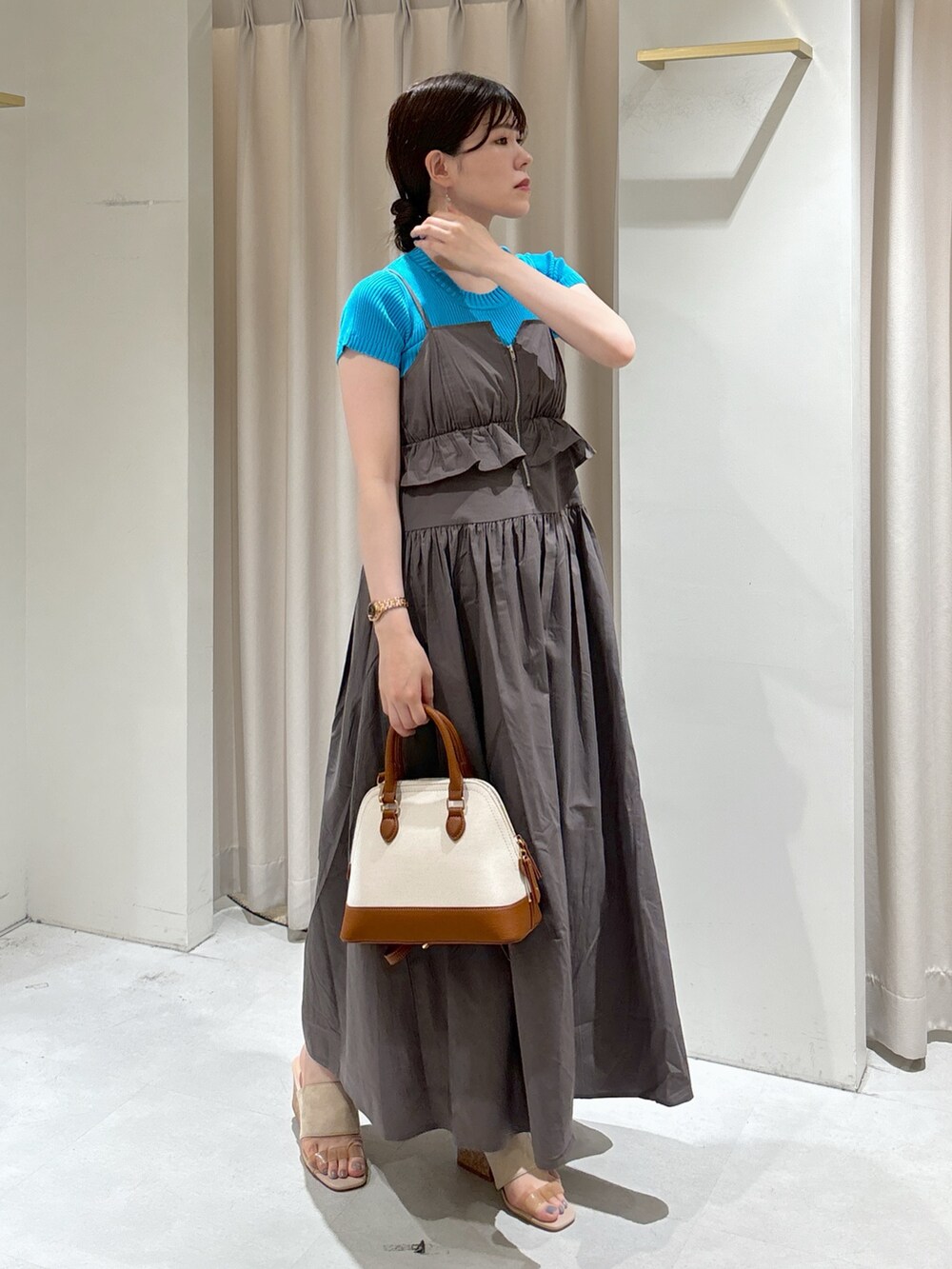 グレー系のワンピース、ブルー系のニット/セーター、ブラウン系のショルダーバッグを着用したレディースの夏コーディネートの2枚目の写真