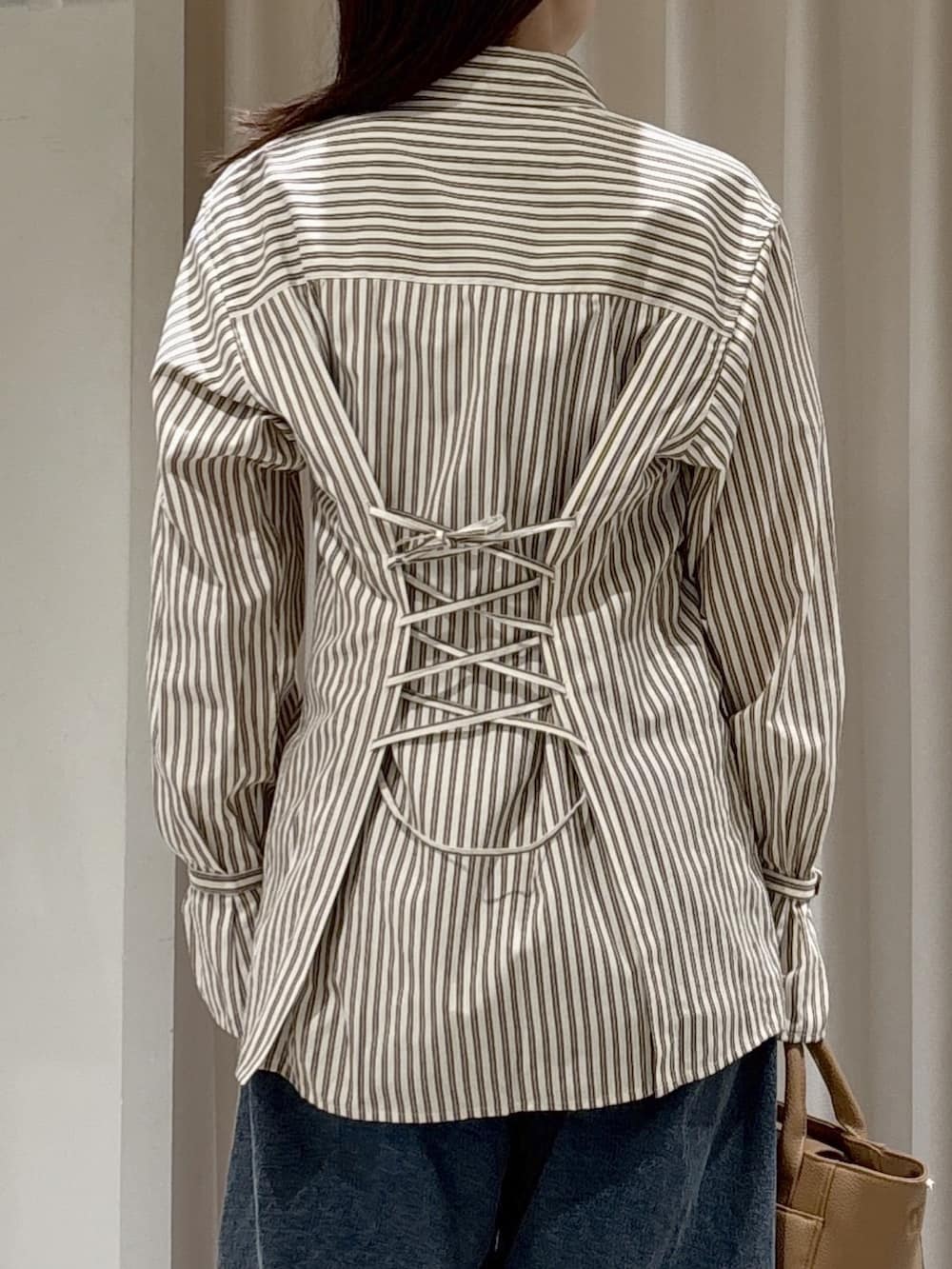 ブラック系のシャツ/ブラウス、ブラウン系のシャツ/ブラウス、ベージュ系のハンドバッグを着用したレディースの冬コーディネートの6枚目の写真