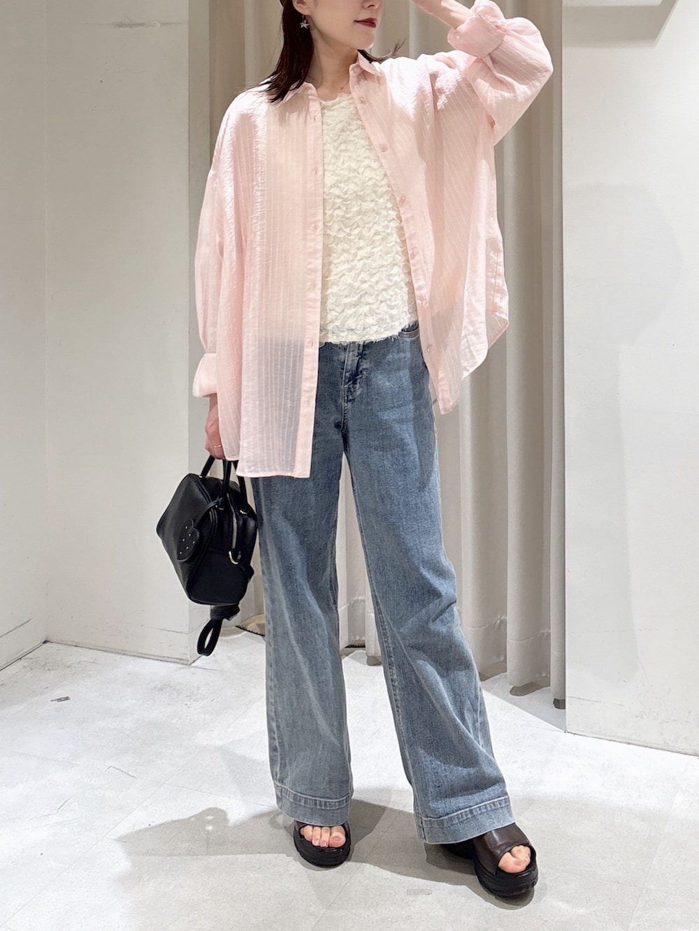 ホワイト系のシャツ/ブラウス、ブルー系のデニムパンツ、ブラック系のボストンバッグを着用したレディースの春コーディネートの5枚目の写真