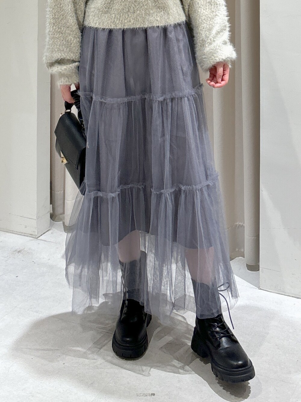 ブラック系のダウンジャケット/コート、グレー系のスカート、ブラック系のブーツを着用したレディースの秋コーディネートの8枚目の写真