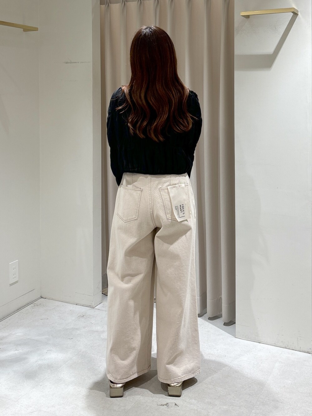 ブラウン系のトートバッグ、ホワイト系のデニムパンツ、ゴールド系のパンプスを着用したレディースの春コーディネートの4枚目の写真