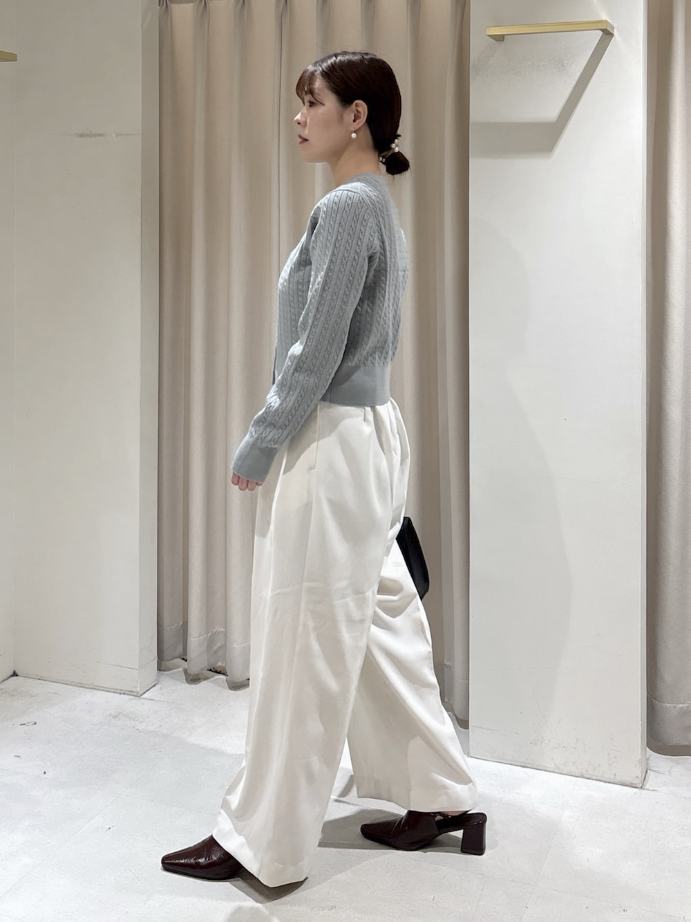 ブルー系のカーディガン/ボレロ、ホワイト系のその他パンツ、ブラック系のトートバッグを着用したレディースの秋コーディネートの3枚目の写真