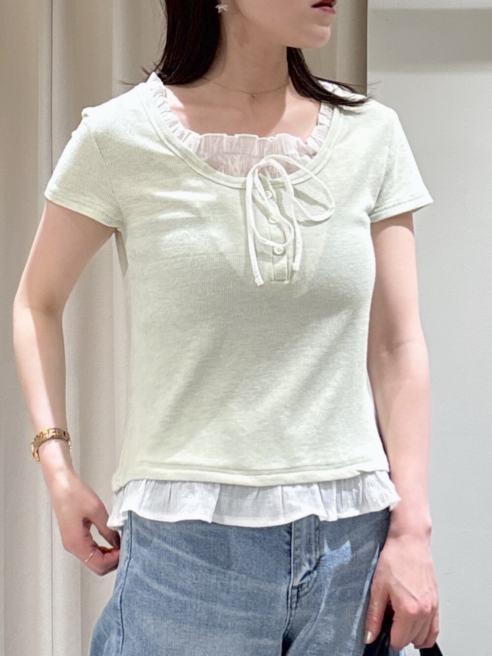 ベージュ系のテーラードジャケット、グリーン系のTシャツ/カットソー、ブルー系のデニムパンツを着用したレディースの春コーディネートの5枚目の写真