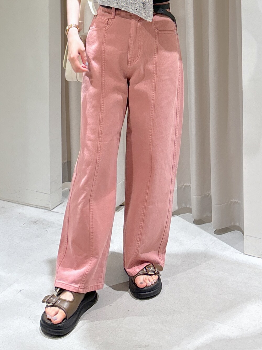 グレー系のニット/セーター、ブラック系のキャミソール、ピンク系のデニムパンツを着用したレディースの夏コーディネートの5枚目の写真