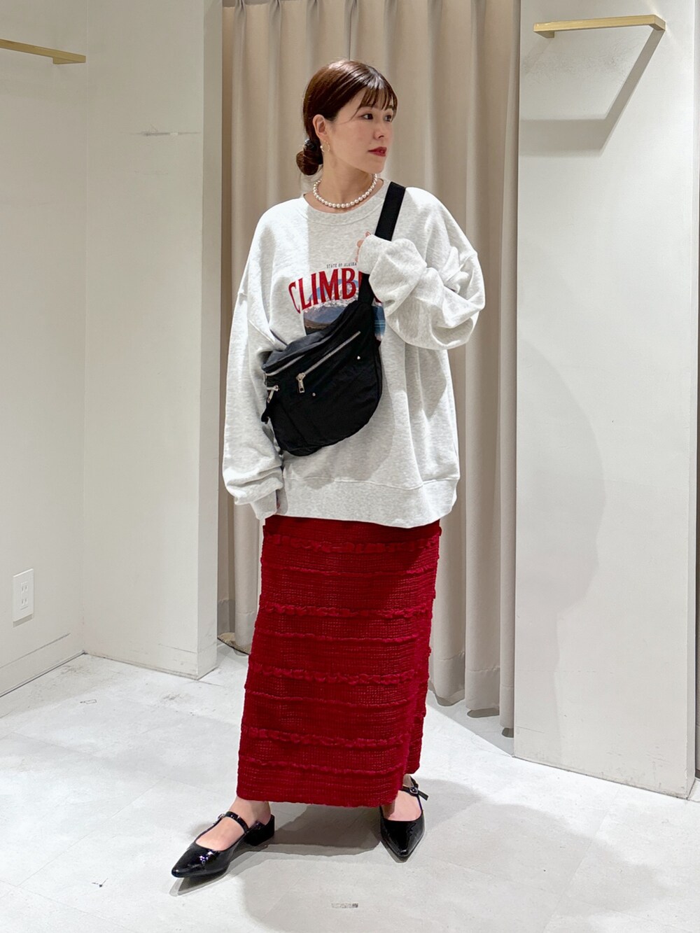 ホワイト系のスウェット、レッド系のスカート、ブラック系のパンプスを着用したレディースの秋コーディネートの7枚目の写真