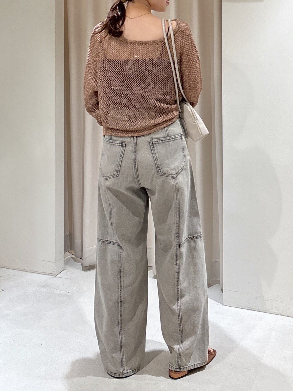 ブラウン系のニット/セーター、ブラック系のキャミソール、グレー系のデニムパンツを着用したレディースの秋コーディネートの6枚目の写真