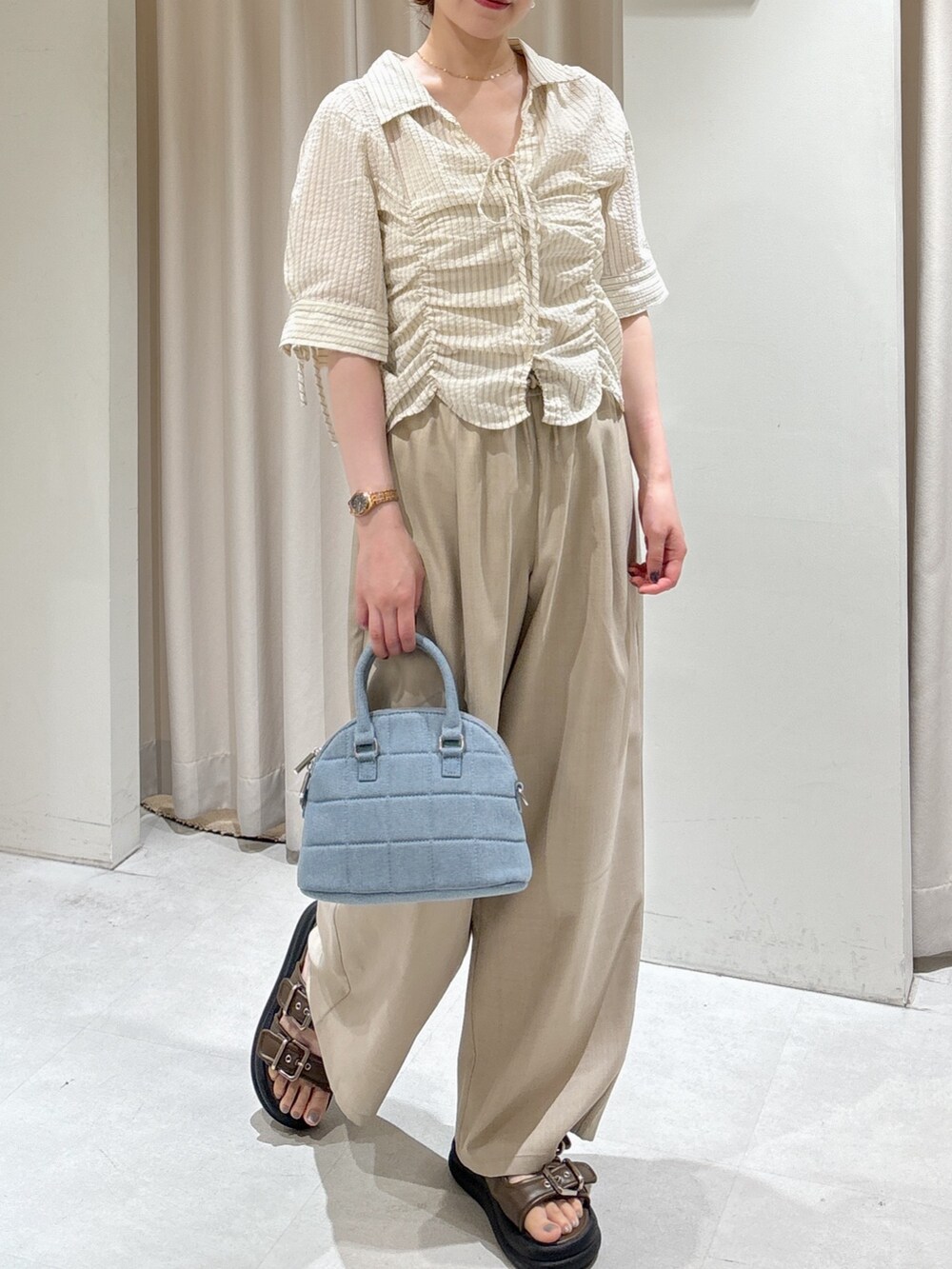 ベージュ系のその他パンツ、ブルー系のトートバッグ、ブラウン系のサンダルを着用したレディースの夏コーディネートの2枚目の写真