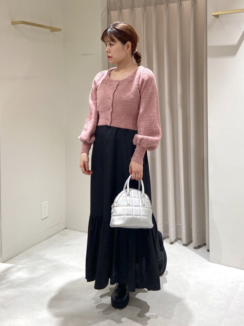 ピンク系のニット/セーター、ブラック系のワンピース、シルバー系のショルダーバッグを着用したレディースの冬コーディネートの4枚目の写真