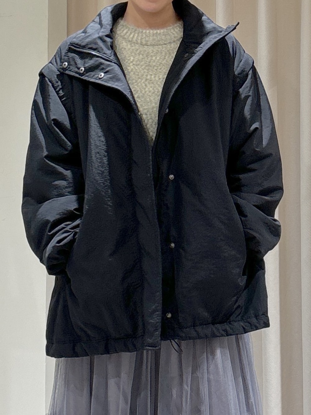 ブラック系のダウンジャケット/コート、グレー系のスカート、ブラック系のブーツを着用したレディースの秋コーディネートの3枚目の写真