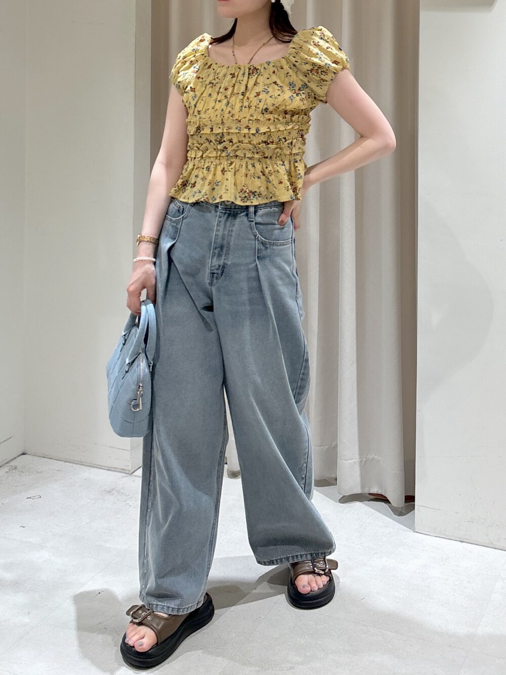 イエロー系のシャツ/ブラウス、ブルー系のトートバッグ、ブルー系のデニムパンツを着用したレディースの夏コーディネートの8枚目の写真