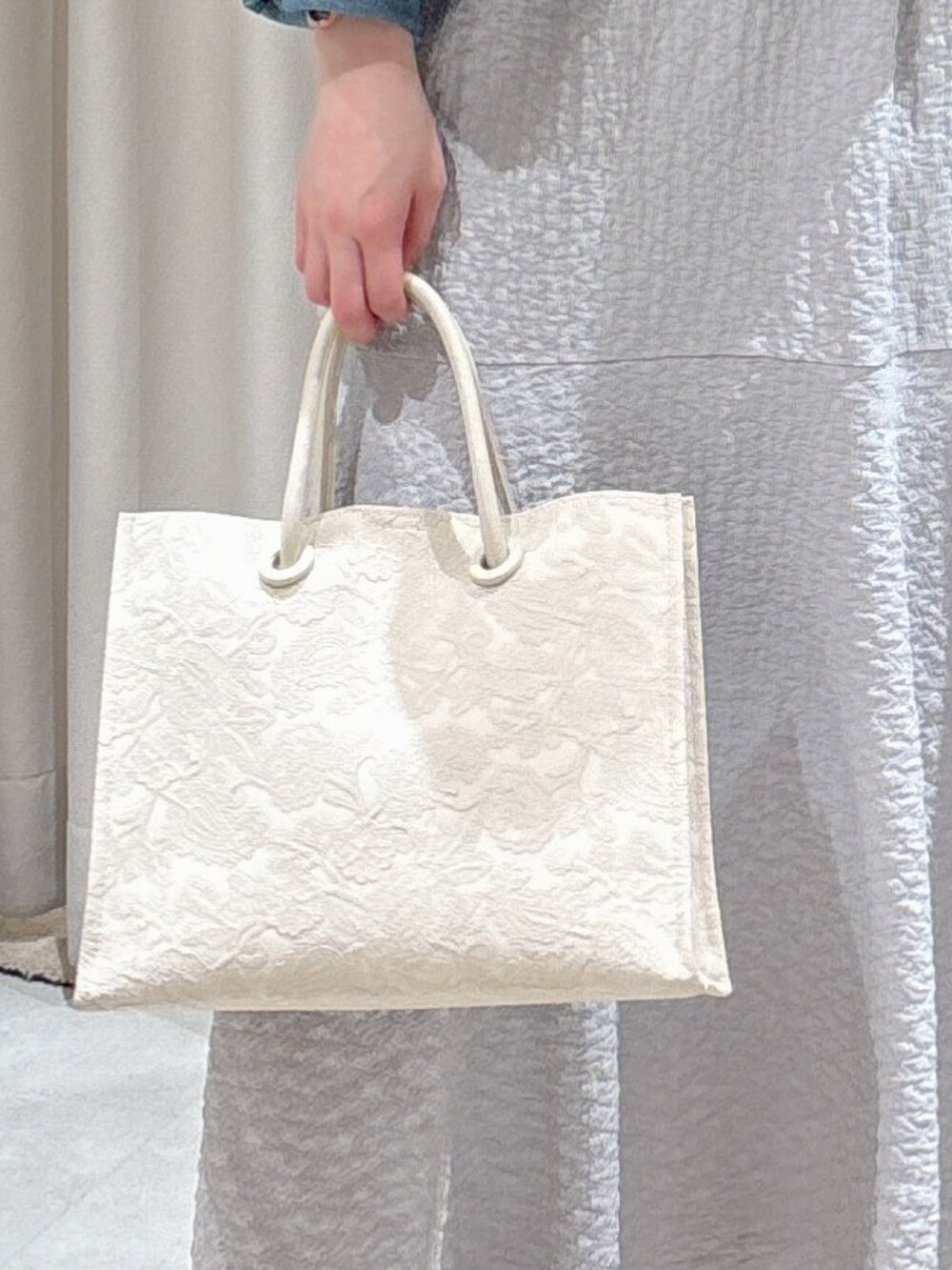 ブルー系のブルゾン、グレー系のワンピース、ホワイト系のトートバッグを着用したレディースの春コーディネートの10枚目の写真