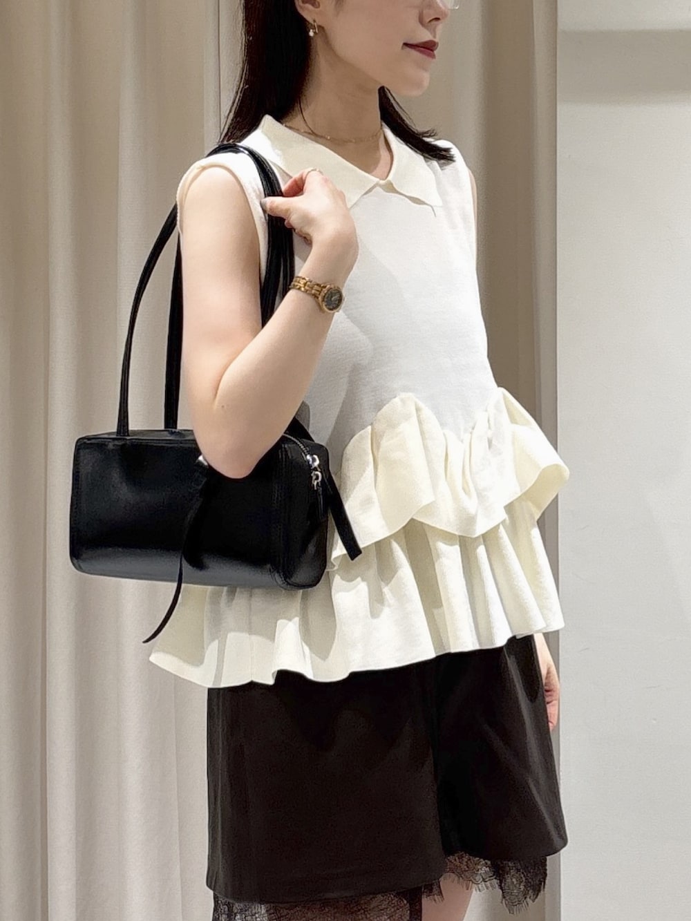 ホワイト系のニット/セーター、ブラウン系のその他パンツ、ブラック系のショルダーバッグを着用したレディースの夏コーディネートの4枚目の写真