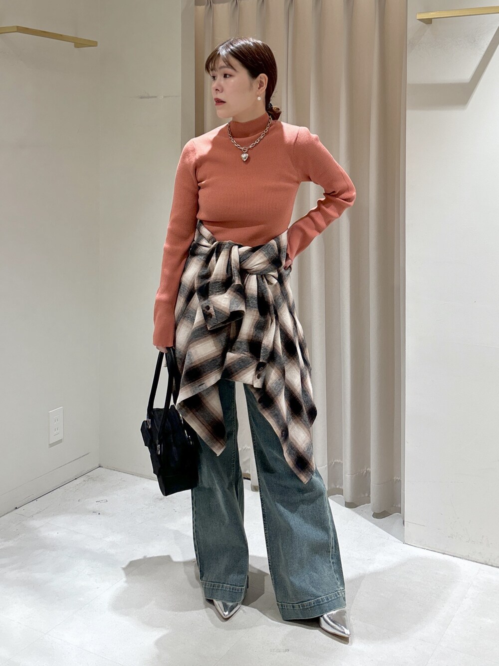 ブラウン系のシャツ/ブラウス、ピンク系のニット/セーター、ブラック系のトートバッグを着用したレディースの冬コーディネートの5枚目の写真