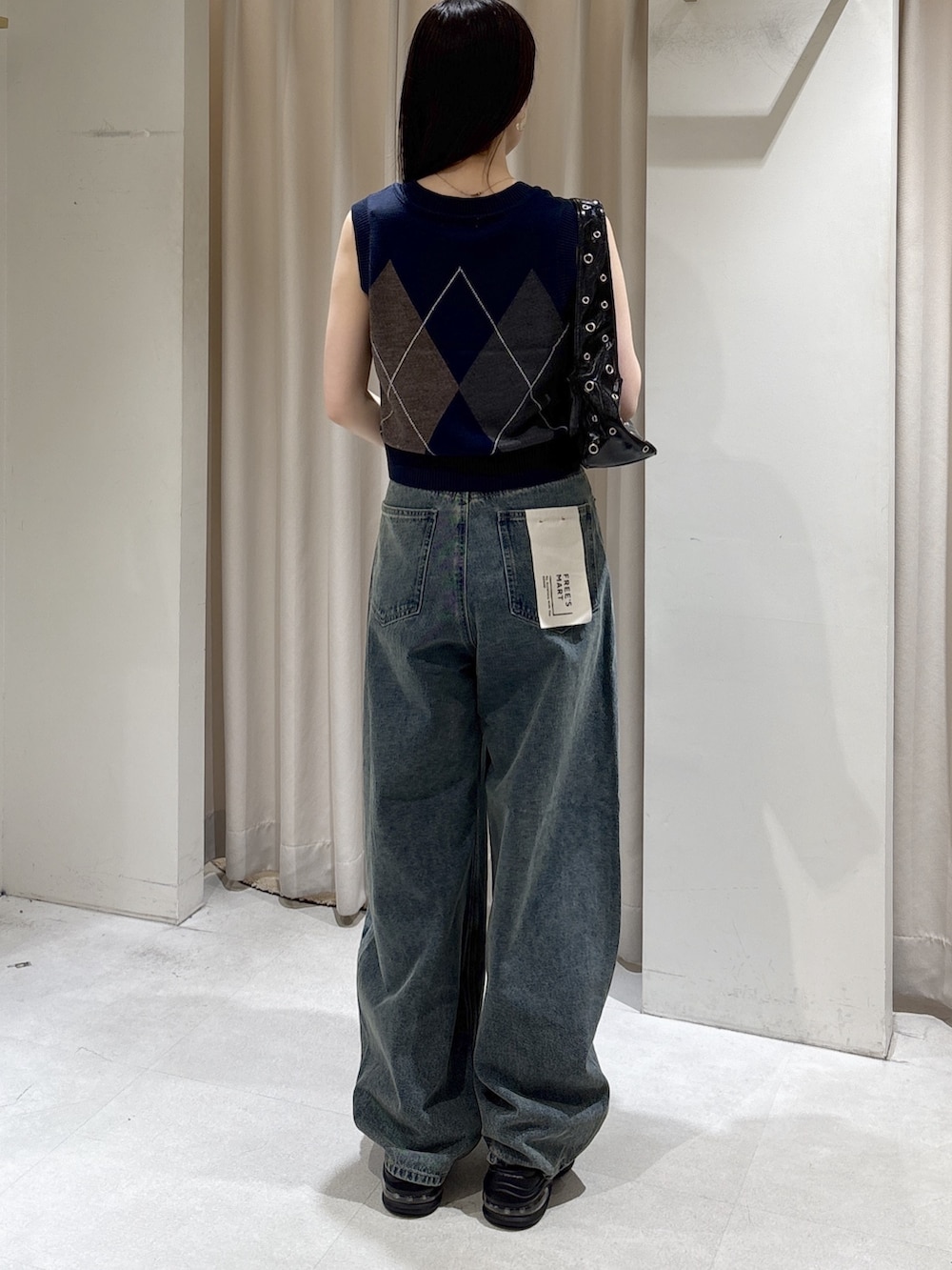 ブルー系のニット/セーター、ブルー系のデニムパンツ、ブラック系のショルダーバッグを着用したレディースの夏コーディネートの4枚目の写真