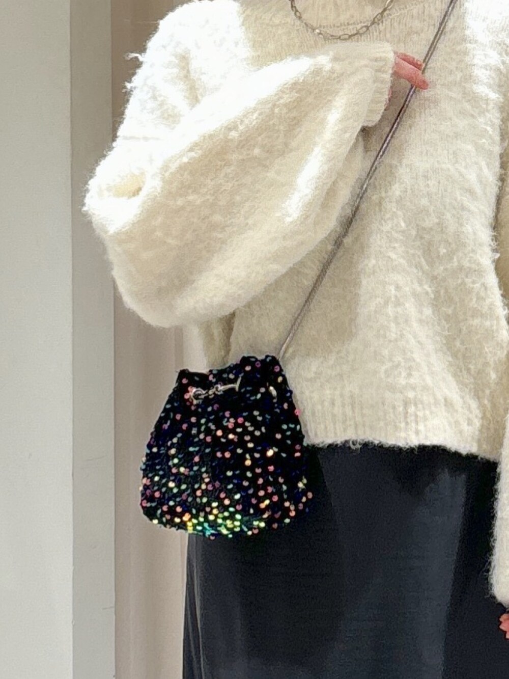 ブラック系のショルダーバッグ、グレー系のスカート、ブラック系のブーツを着用したレディースの冬コーディネートの6枚目の写真