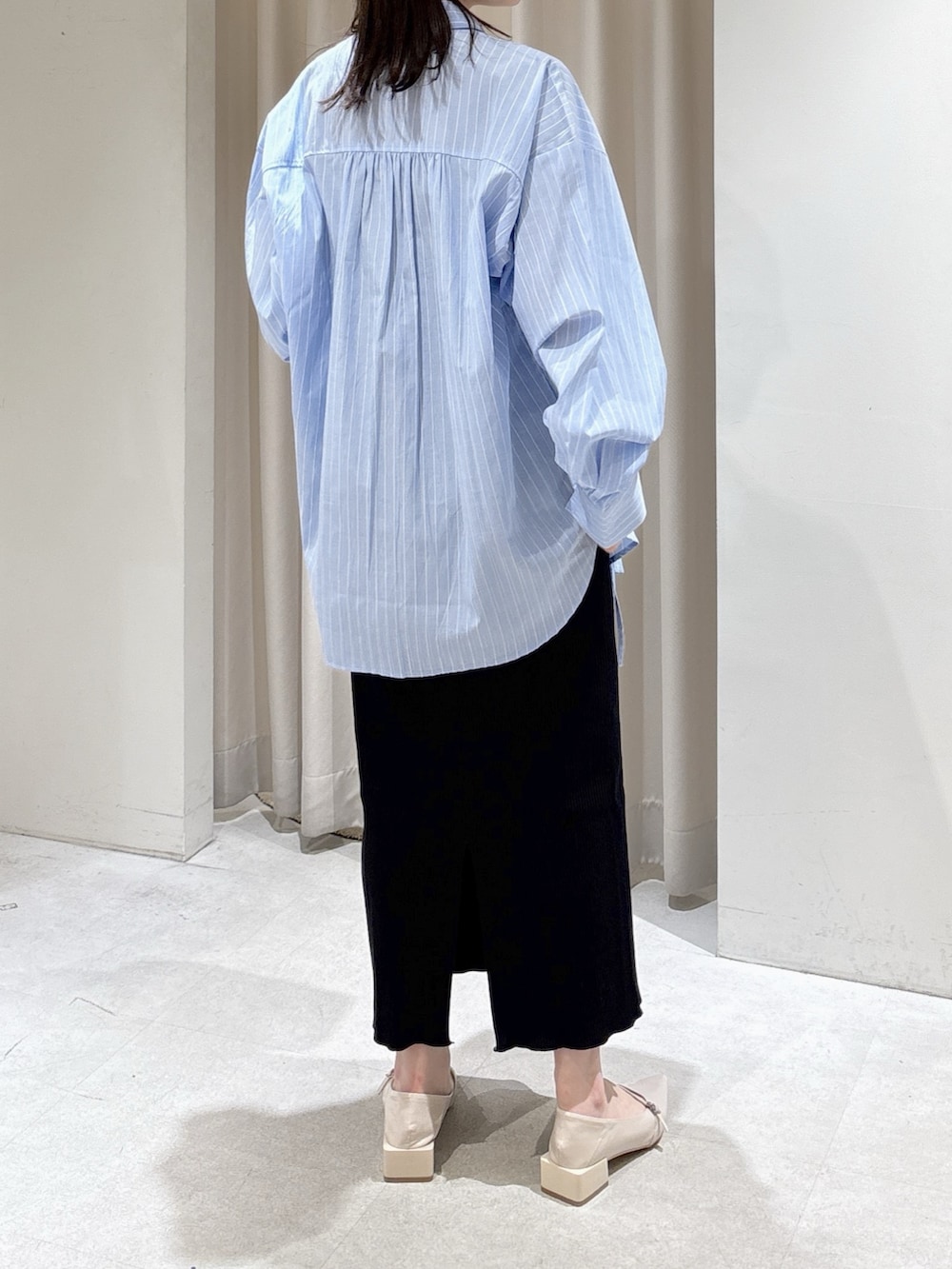 ブルー系のシャツ/ブラウス、ブラック系のハンドバッグ、ブラック系のスカートを着用したレディースの春コーディネートの4枚目の写真