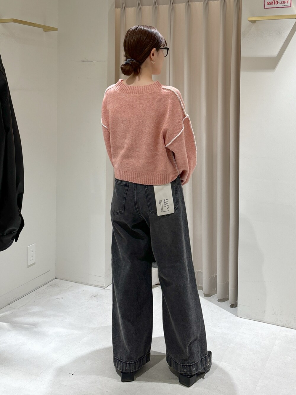 ピンク系のニット/セーター、ブラック系のデニムパンツ、グレー系のハンドバッグを着用したレディースの秋コーディネートの4枚目の写真