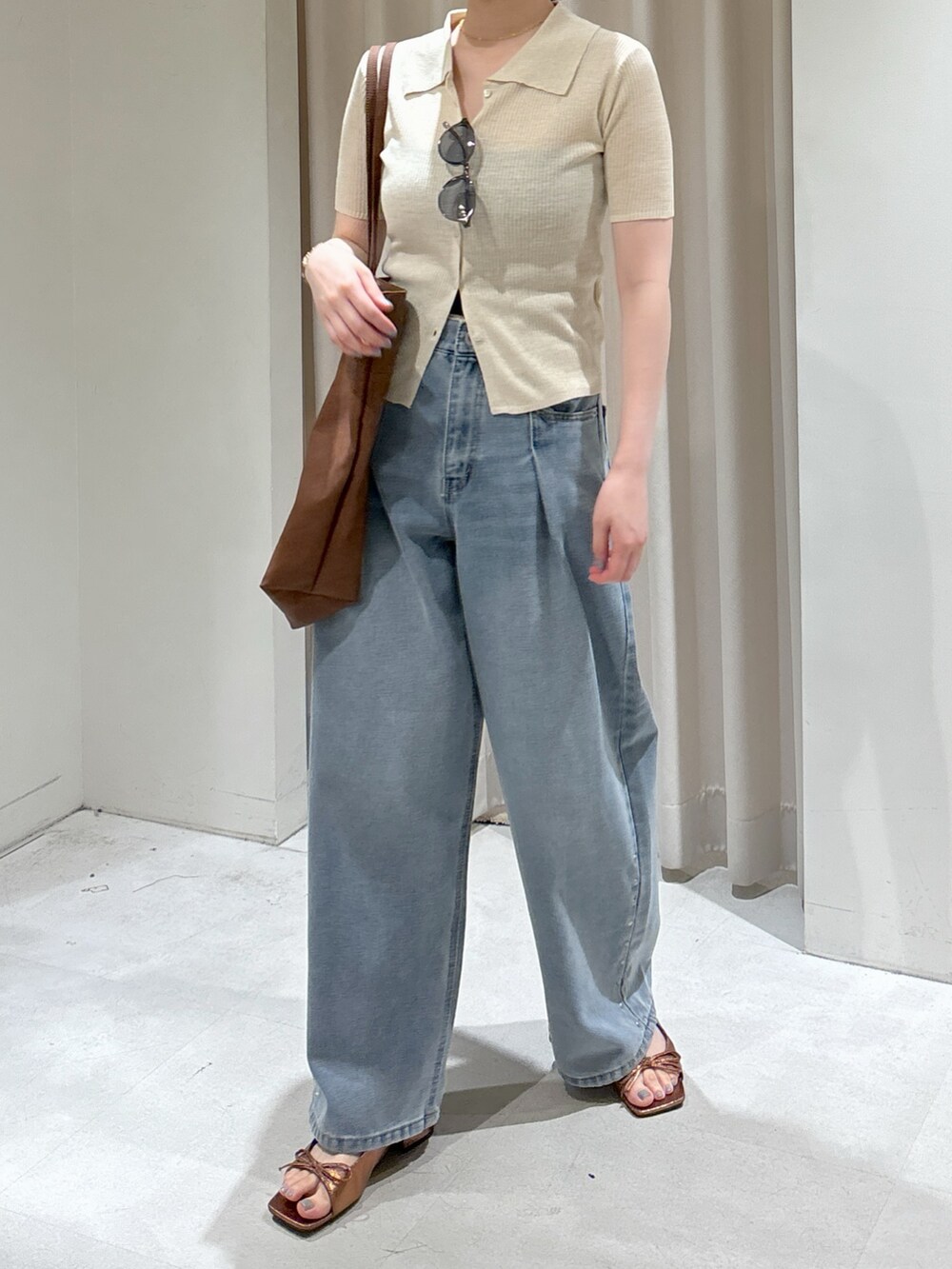 ブルー系のデニムパンツ、ブラウン系のサンダル、ブラック系のキャミソールを着用したレディースの春コーディネートの8枚目の写真