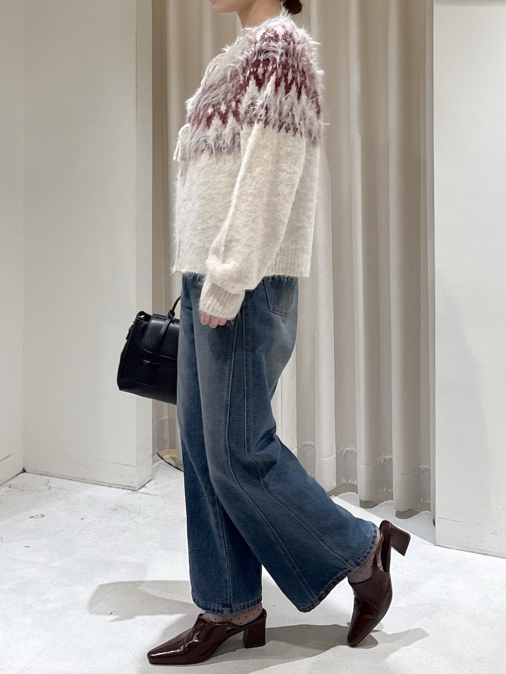 ホワイト系のニット/セーター、ブルー系のデニムパンツ、ブラウン系のパンプスを着用したレディースの秋コーディネートの5枚目の写真