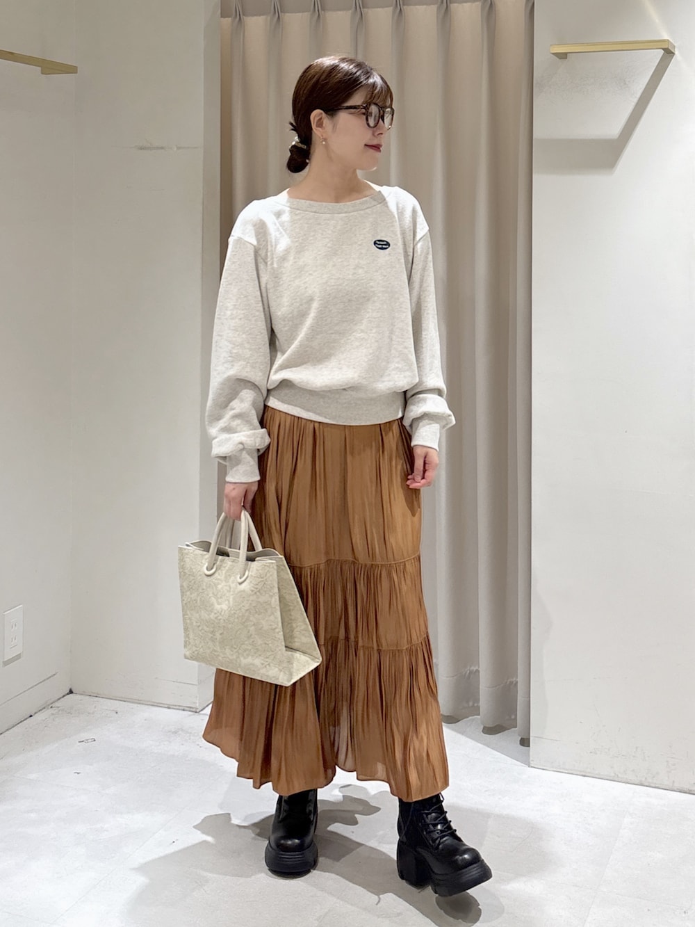 ホワイト系のTシャツ/カットソー、ベージュ系のスカート、ホワイト系のトートバッグを着用したレディースの秋コーディネートの4枚目の写真