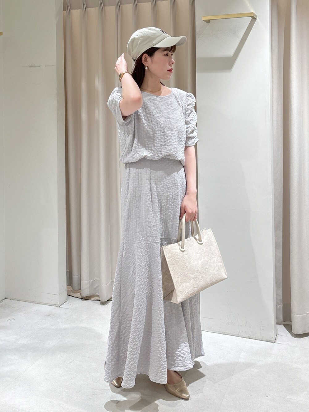 ブルー系のブルゾン、グレー系のワンピース、ホワイト系のトートバッグを着用したレディースの春コーディネートの7枚目の写真