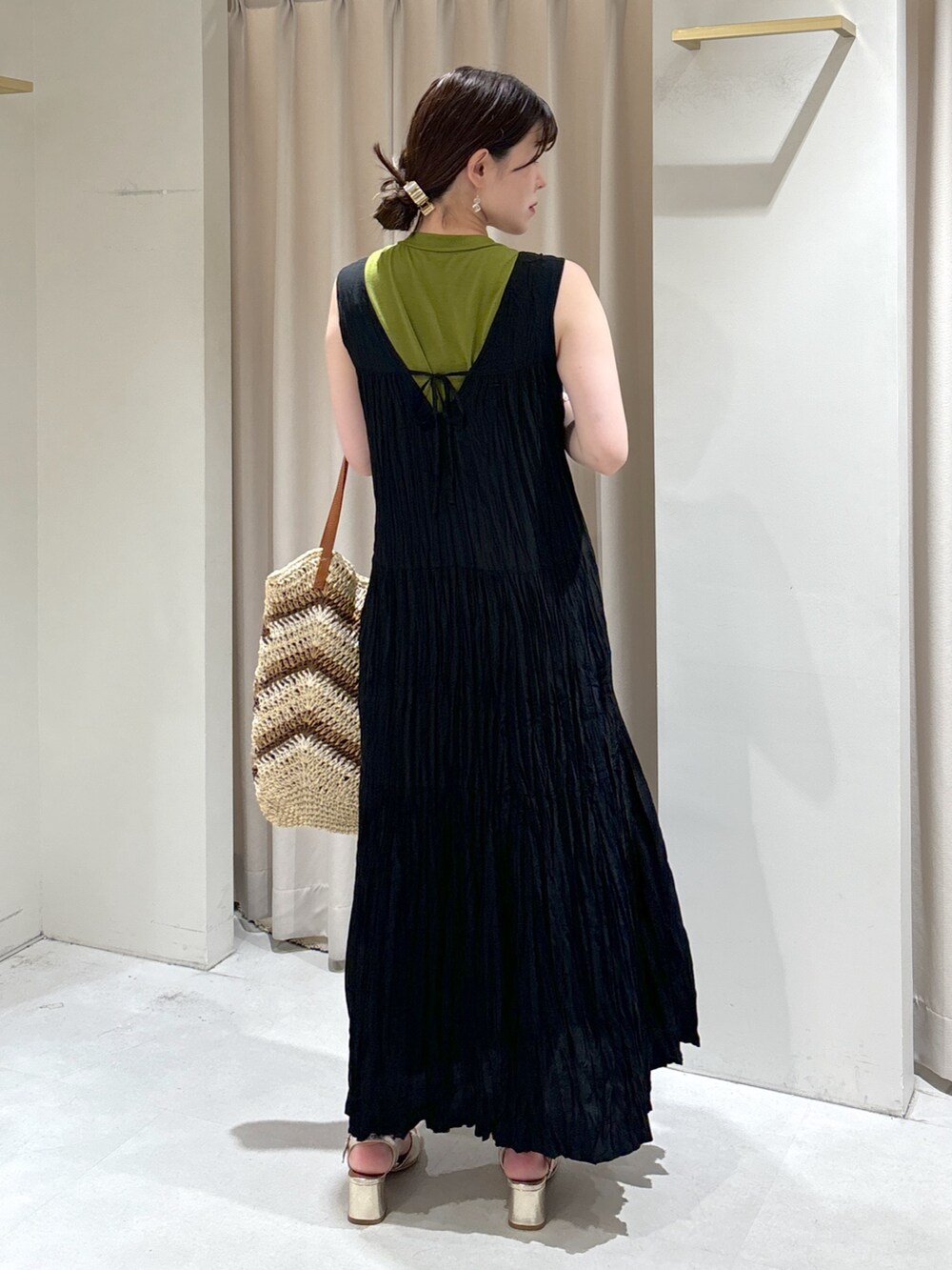 ブラック系のワンピース、ベージュ系のトートバッグ、ゴールド系のサンダルを着用したレディースの夏コーディネートの6枚目の写真