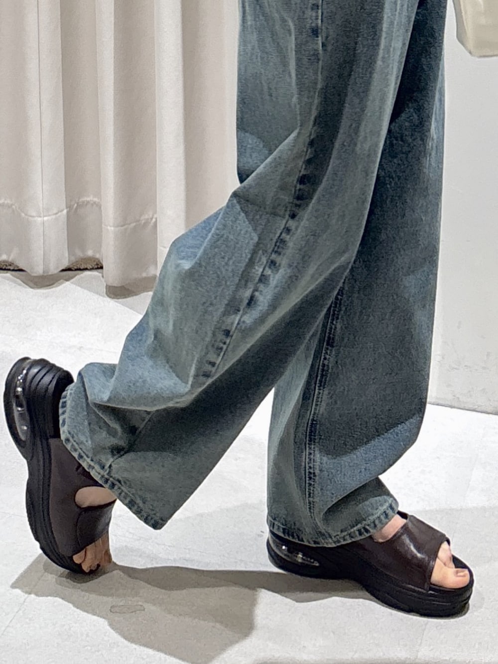 ブラウン系のニット/セーター、ブルー系のデニムパンツ、ブラウン系のサンダルを着用したレディースの夏コーディネートの5枚目の写真