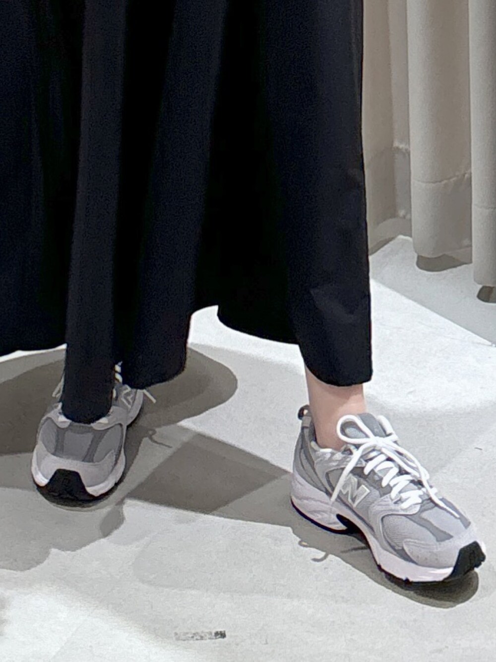 ホワイト系のカーディガン/ボレロ、ブラック系のワンピース、ブラック系のショルダーバッグを着用したレディースの秋コーディネートの7枚目の写真