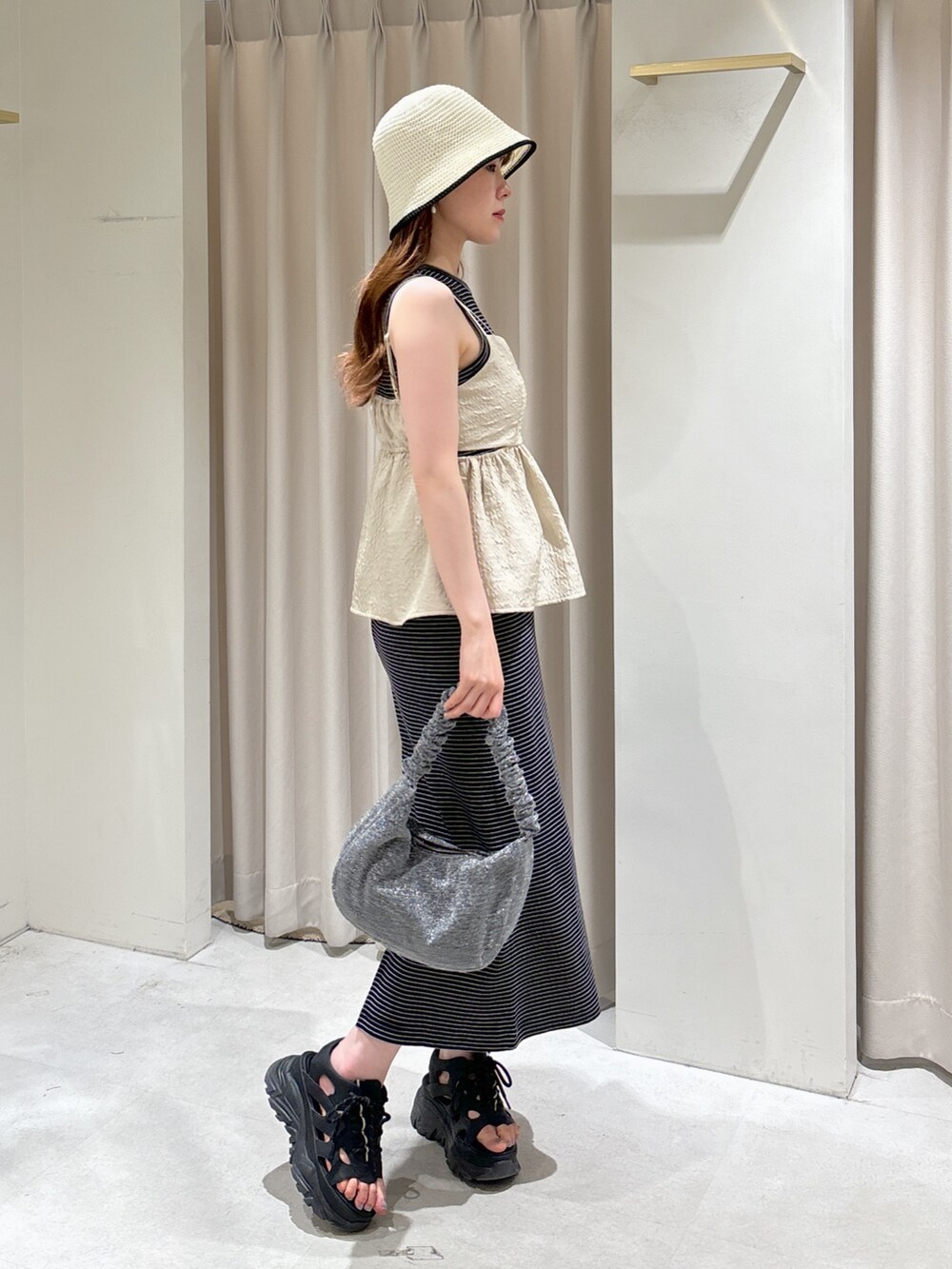 ホワイト系のシャツ/ブラウス、ブラック系のサンダル、シルバー系のハンドバッグを着用したレディースの春コーディネートの3枚目の写真