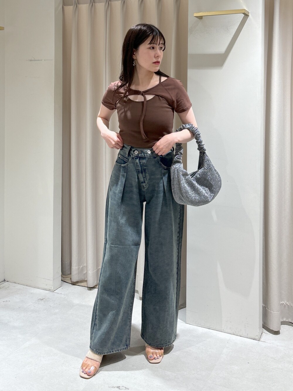 ブラウン系のTシャツ/カットソー、ブルー系のデニムパンツ、シルバー系のハンドバッグを着用したレディースの夏コーディネートの2枚目の写真