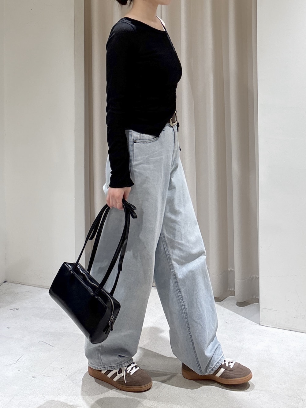 ブラック系のTシャツ/カットソー、ブルー系のデニムパンツ、ブラック系のショルダーバッグを着用したレディースの春コーディネートの4枚目の写真