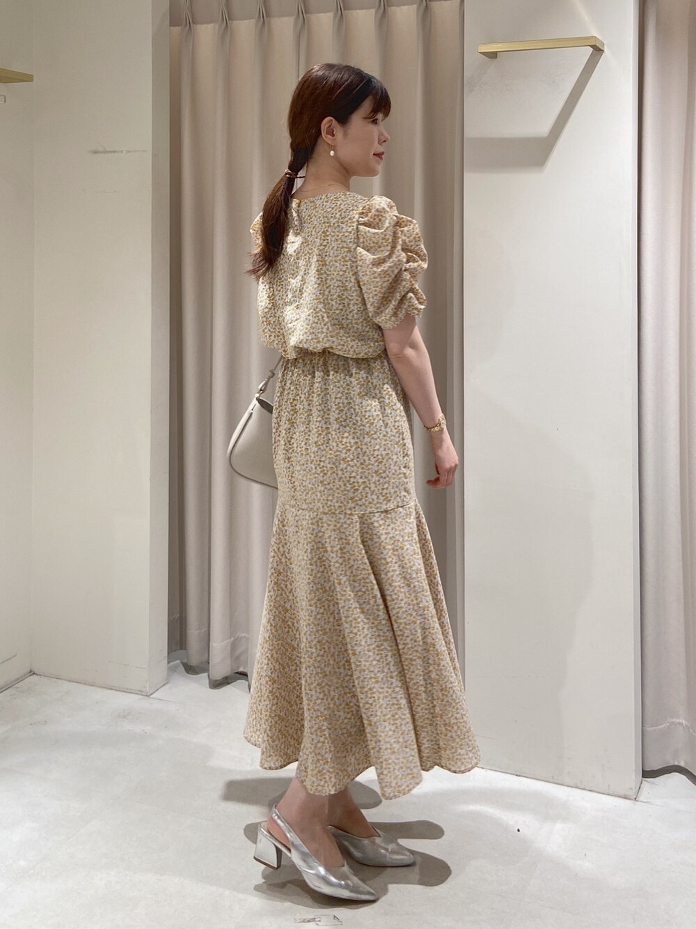 イエロー系のワンピース、グレー系のショルダーバッグ、シルバー系のパンプスを着用したレディースの春コーディネートの4枚目の写真