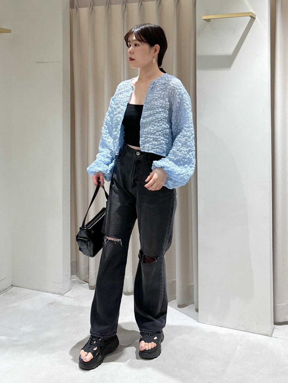 ブルー系のカーディガン/ボレロ、ブラック系のキャミソール、ブラック系のデニムパンツを着用したレディースの夏コーディネートの2枚目の写真