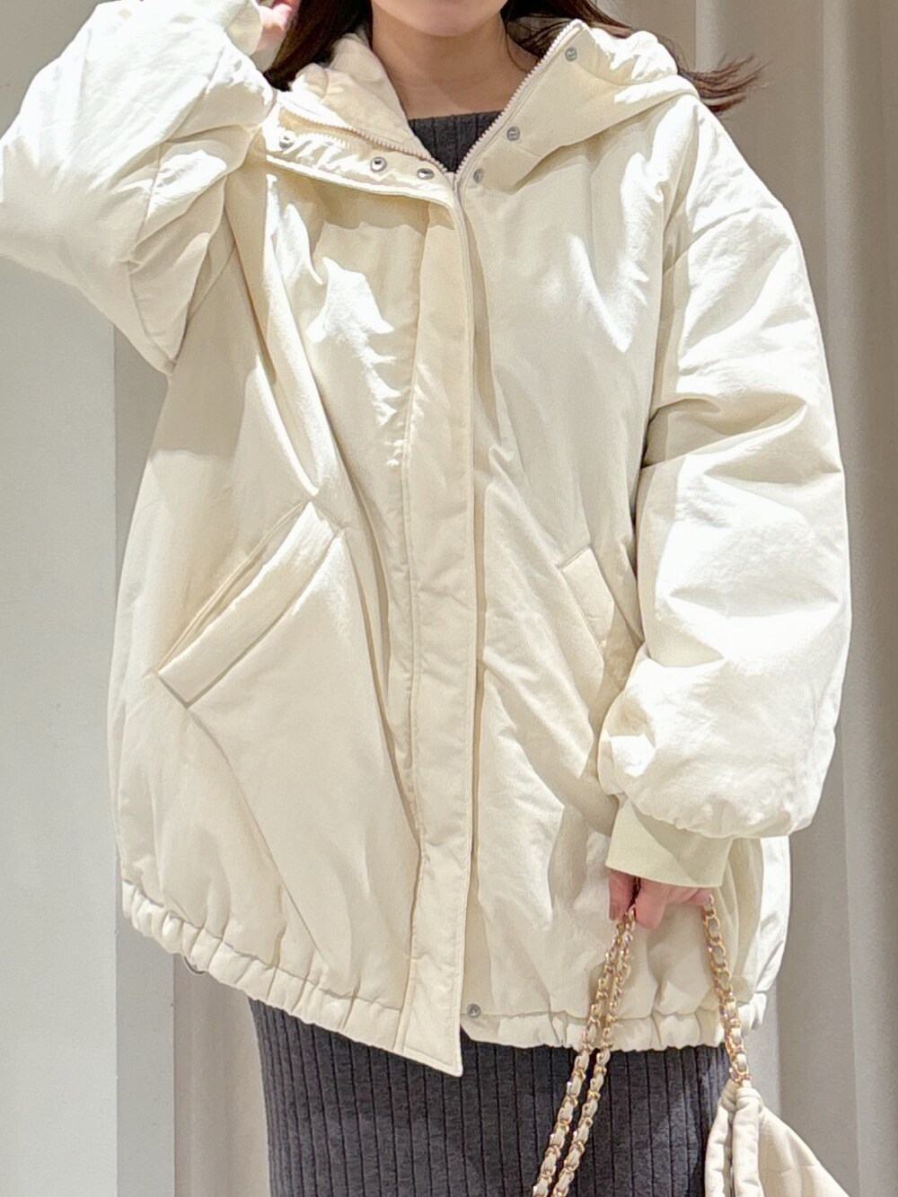 ホワイト系のブルゾン、グレー系のワンピース、ホワイト系のトートバッグを着用したレディースの冬コーディネートの3枚目の写真