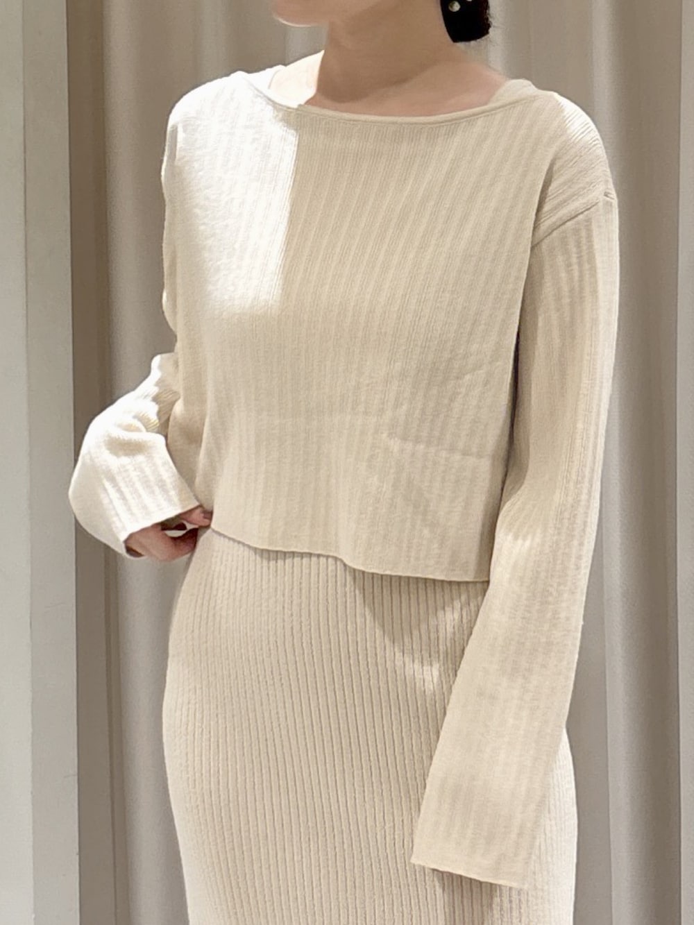 ホワイト系のワンピース、ブラウン系のハンドバッグ、ブラック系のブーツを着用したレディースの冬コーディネートの3枚目の写真