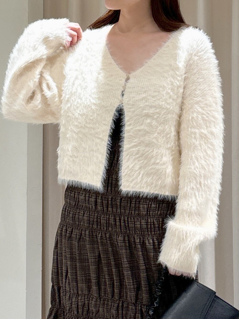 ホワイト系のカーディガン/ボレロ、ブラック系のキャミソール、ブラック系のショルダーバッグを着用したレディースの秋コーディネートの3枚目の写真