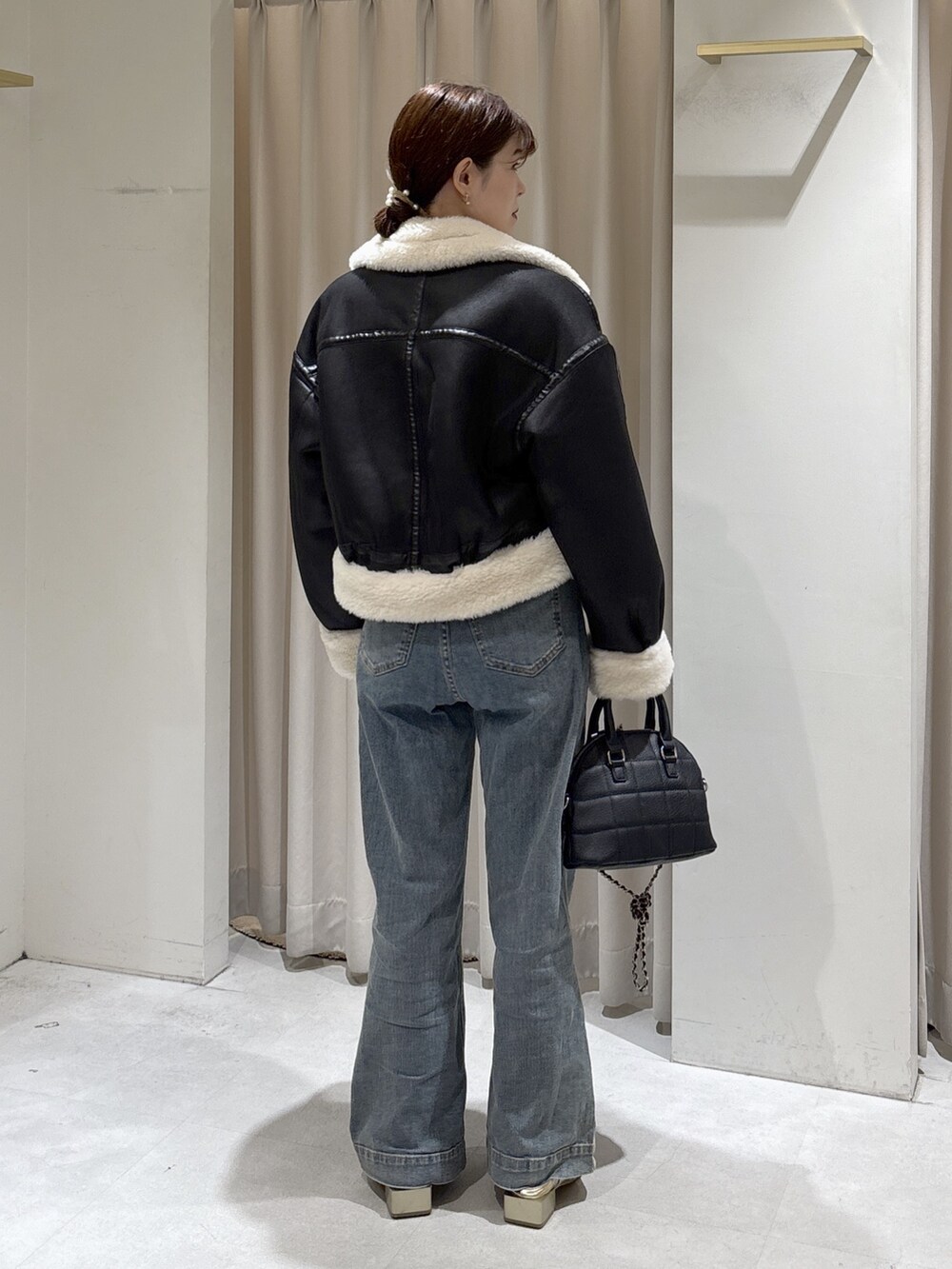 ブラウン系のニット/セーター、ブルー系のデニムパンツ、ブラック系のトートバッグを着用したレディースの秋コーディネートの7枚目の写真