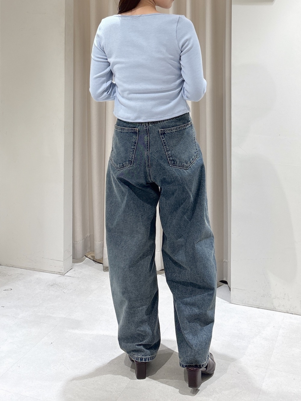 ブルー系のTシャツ/カットソー、ブルー系のデニムパンツ、ブラウン系のパンプスを着用したレディースの冬コーディネートの3枚目の写真