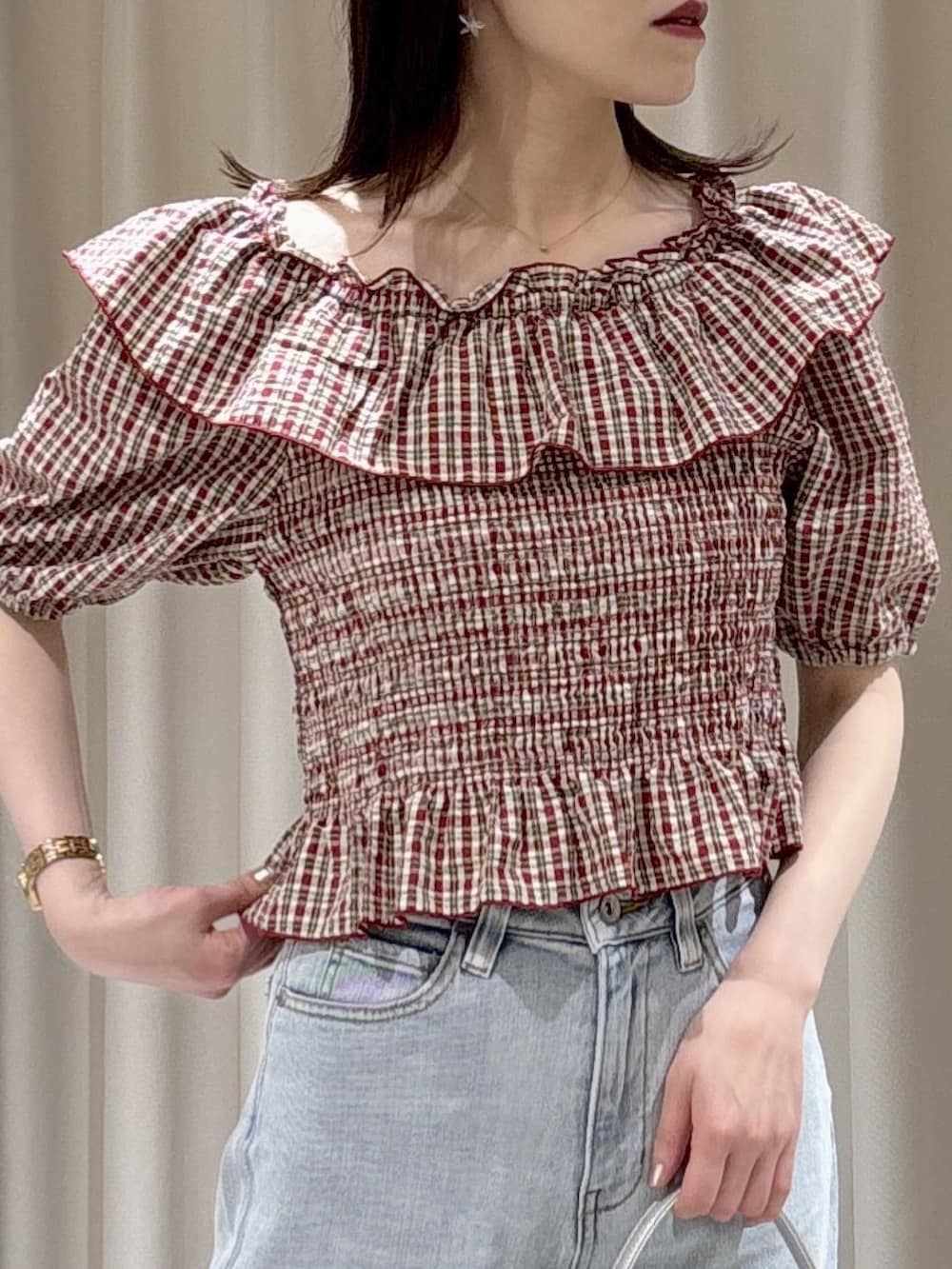 レッド系のシャツ/ブラウス、ブルー系のデニムパンツ、シルバー系のショルダーバッグを着用したレディースの春コーディネートの2枚目の写真