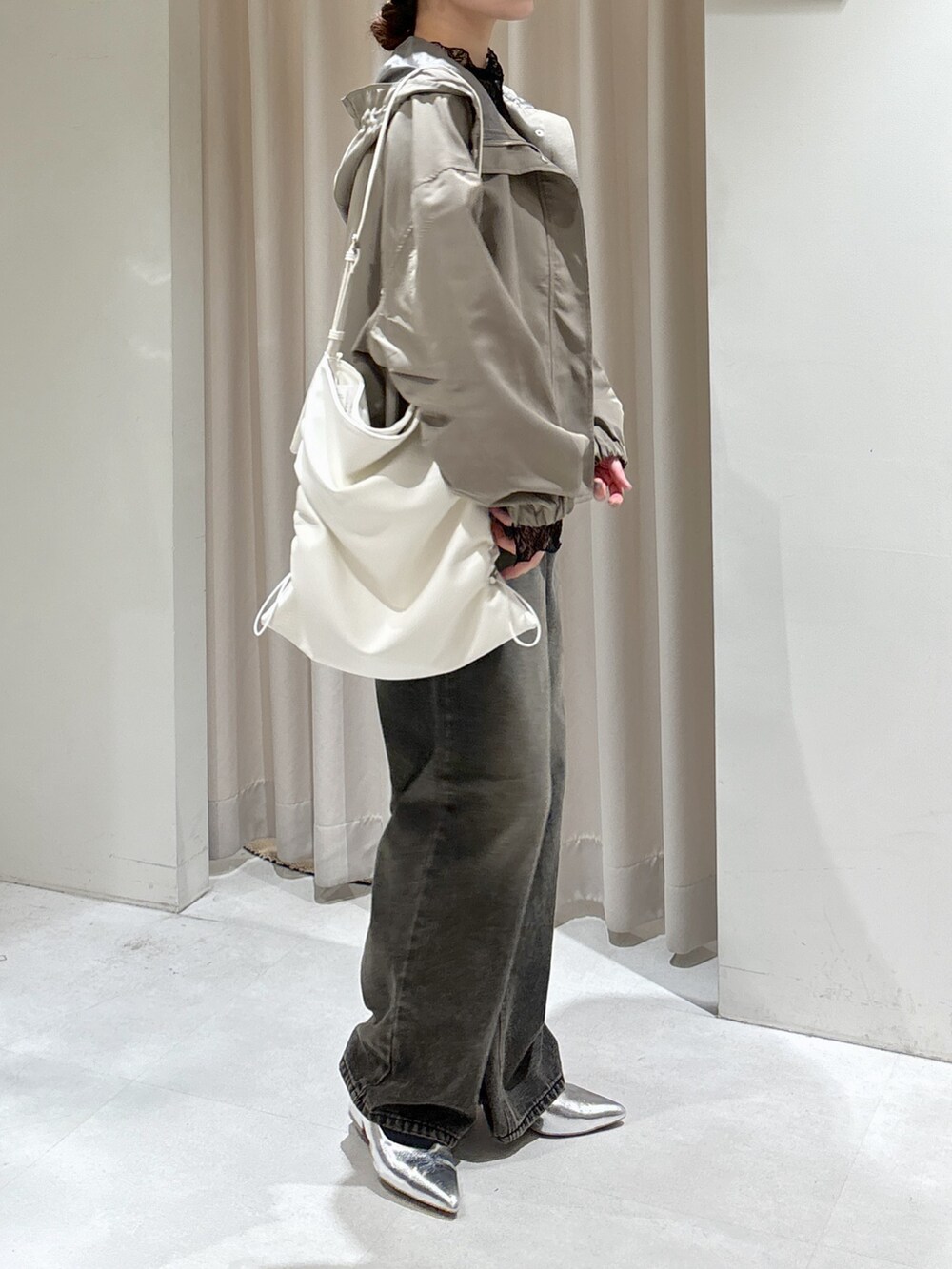 グリーン系のマウンテンパーカー、ブラック系のTシャツ/カットソー、ホワイト系のキャミソールを着用したレディースの冬コーディネートの9枚目の写真