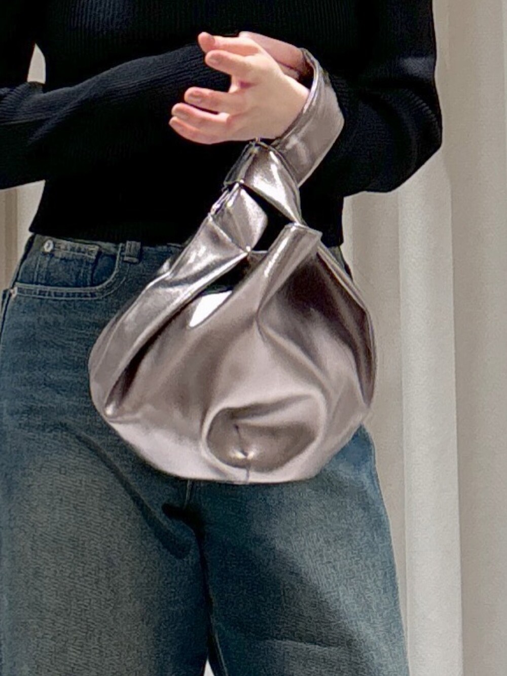 ホワイト系のシャツ/ブラウス、ブラック系のニット/セーター、シルバー系のハンドバッグを着用したレディースの秋コーディネートの7枚目の写真