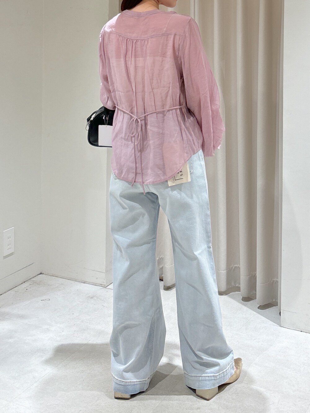 ピンク系のシャツ/ブラウス、ホワイト系のキャミソール、ブラック系のトートバッグを着用したレディースの春コーディネートの4枚目の写真