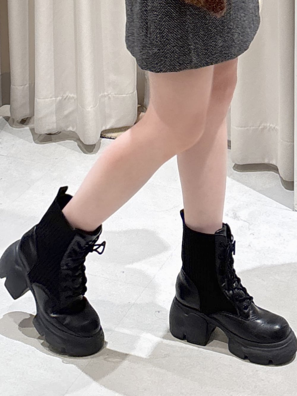 ブラウン系のニット/セーター、ブラック系のスカート、ブラック系のブーツを着用したレディースの冬コーディネートの5枚目の写真