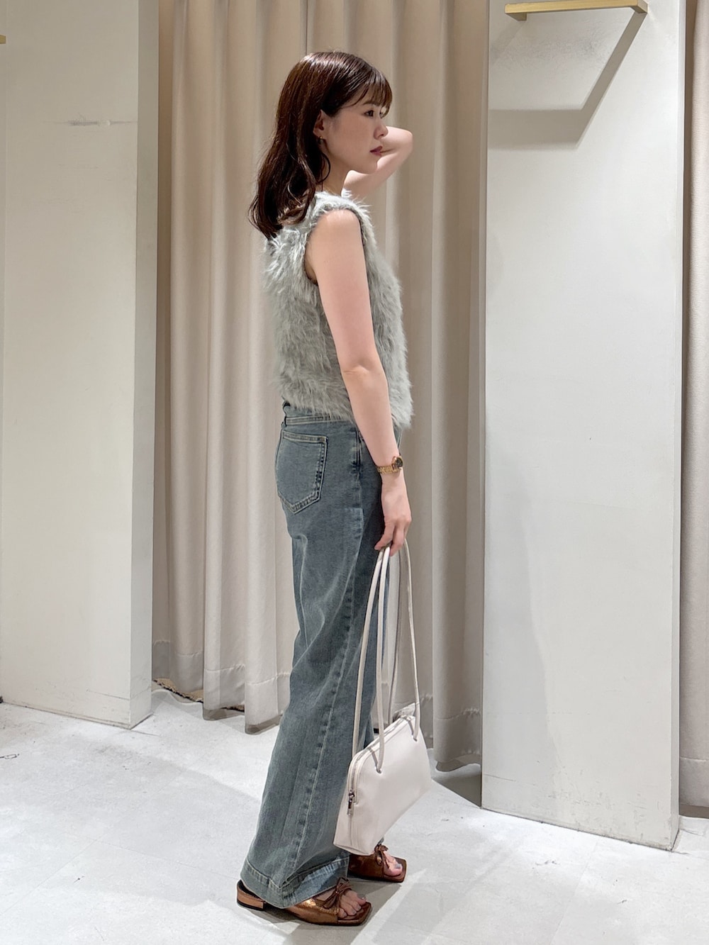 ベージュ系のニット/セーター、ブルー系のデニムパンツ、ブラウン系のサンダルを着用したレディースの夏コーディネートの4枚目の写真