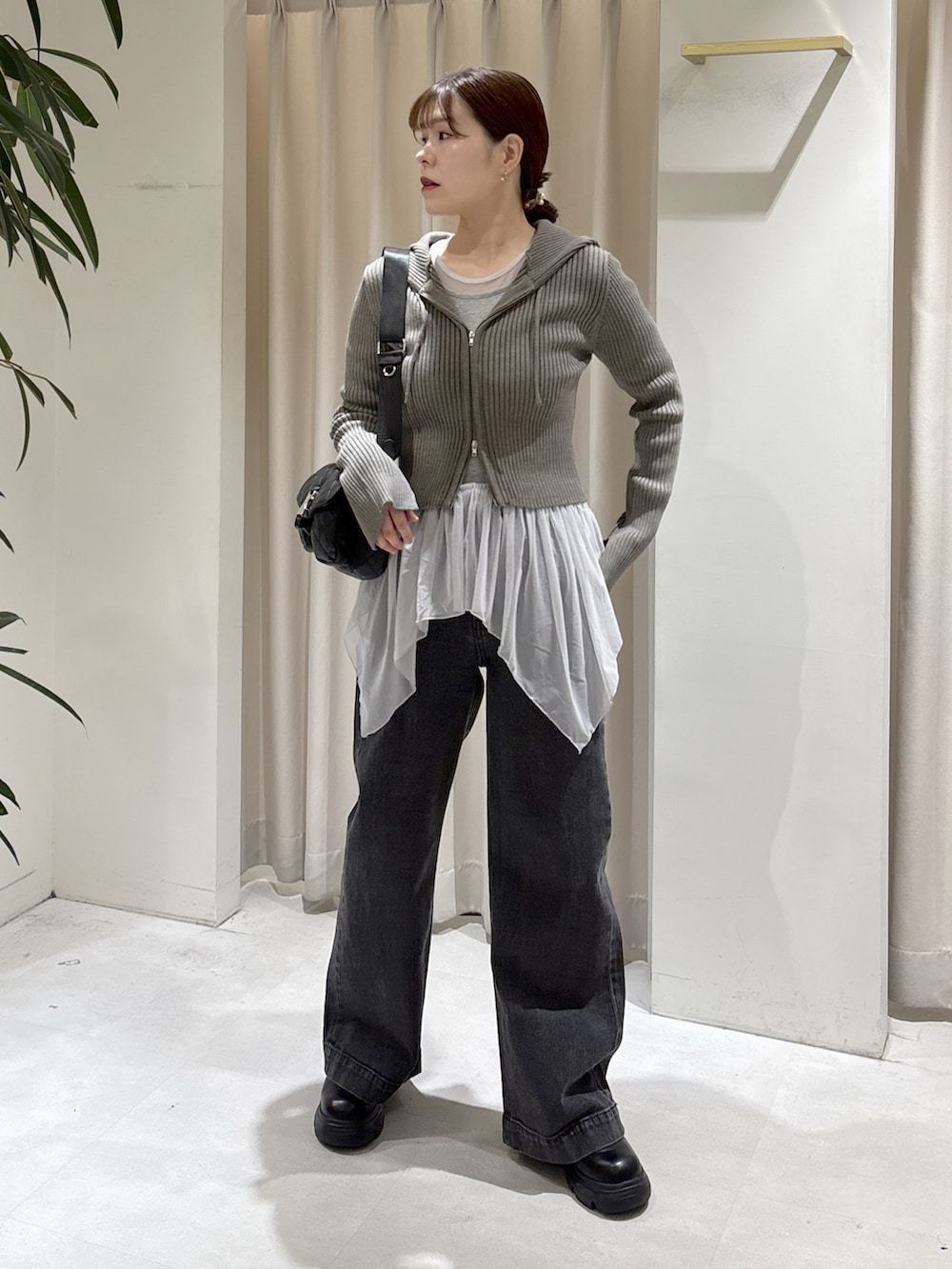 ブラウン系のニット/セーター、グレー系のTシャツ/カットソー、ブラック系のデニムパンツを着用したレディースの秋コーディネートの7枚目の写真