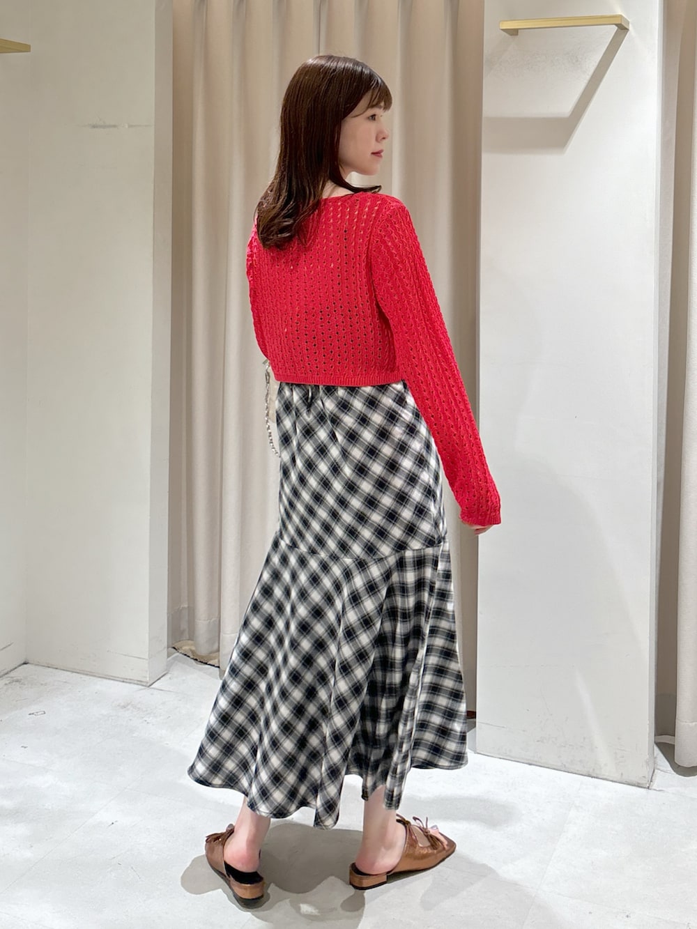 レッド系のカーディガン/ボレロ、ブラック系のワンピース、ホワイト系のトートバッグを着用したレディースの夏コーディネートの9枚目の写真