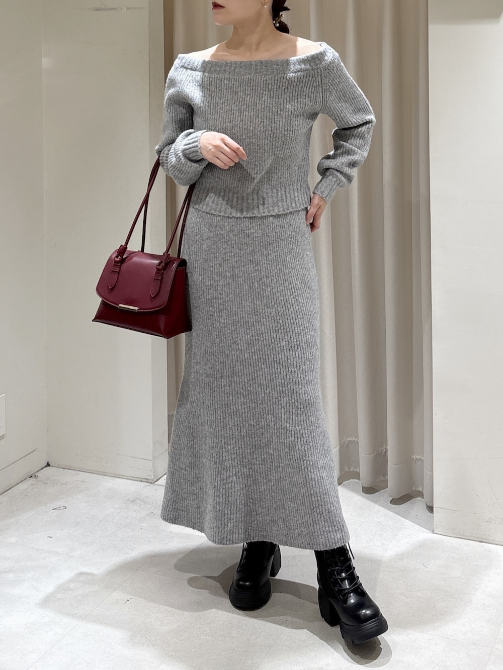 グレー系のワンピース、レッド系のショルダーバッグ、ブラック系のブーツを着用したレディースの秋コーディネートの5枚目の写真