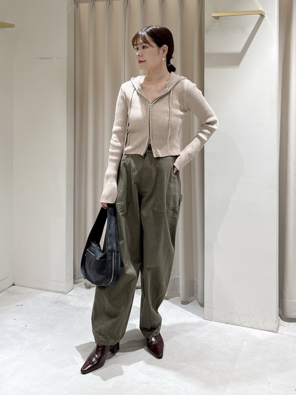 ベージュ系のニット/セーター、ブラック系のハンドバッグ、グリーン系のその他パンツを着用したレディースの秋コーディネートの4枚目の写真